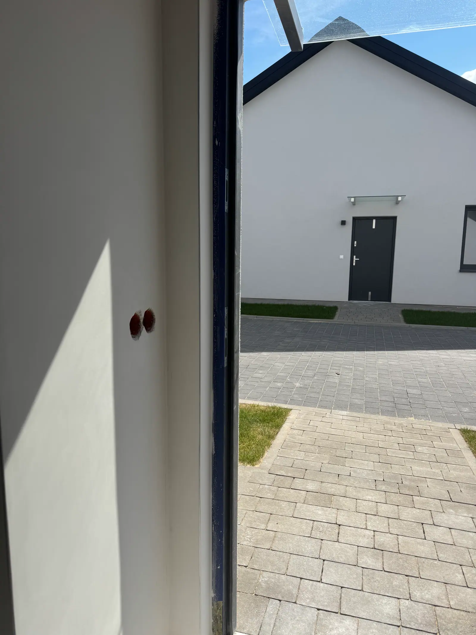 A smooth white reveal beside a large window, with sunlight falling on the wall.